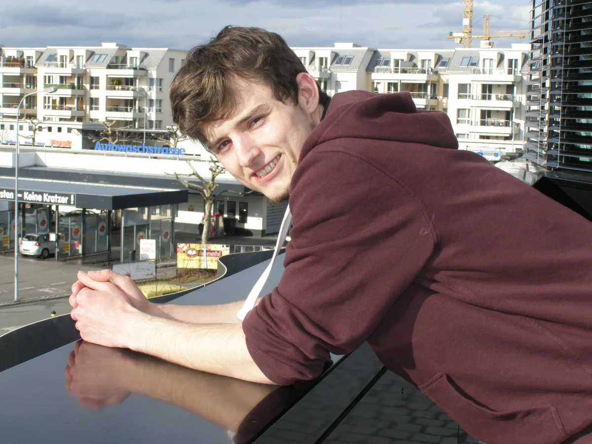 Ein junger Mann schaut in die Kamera.       