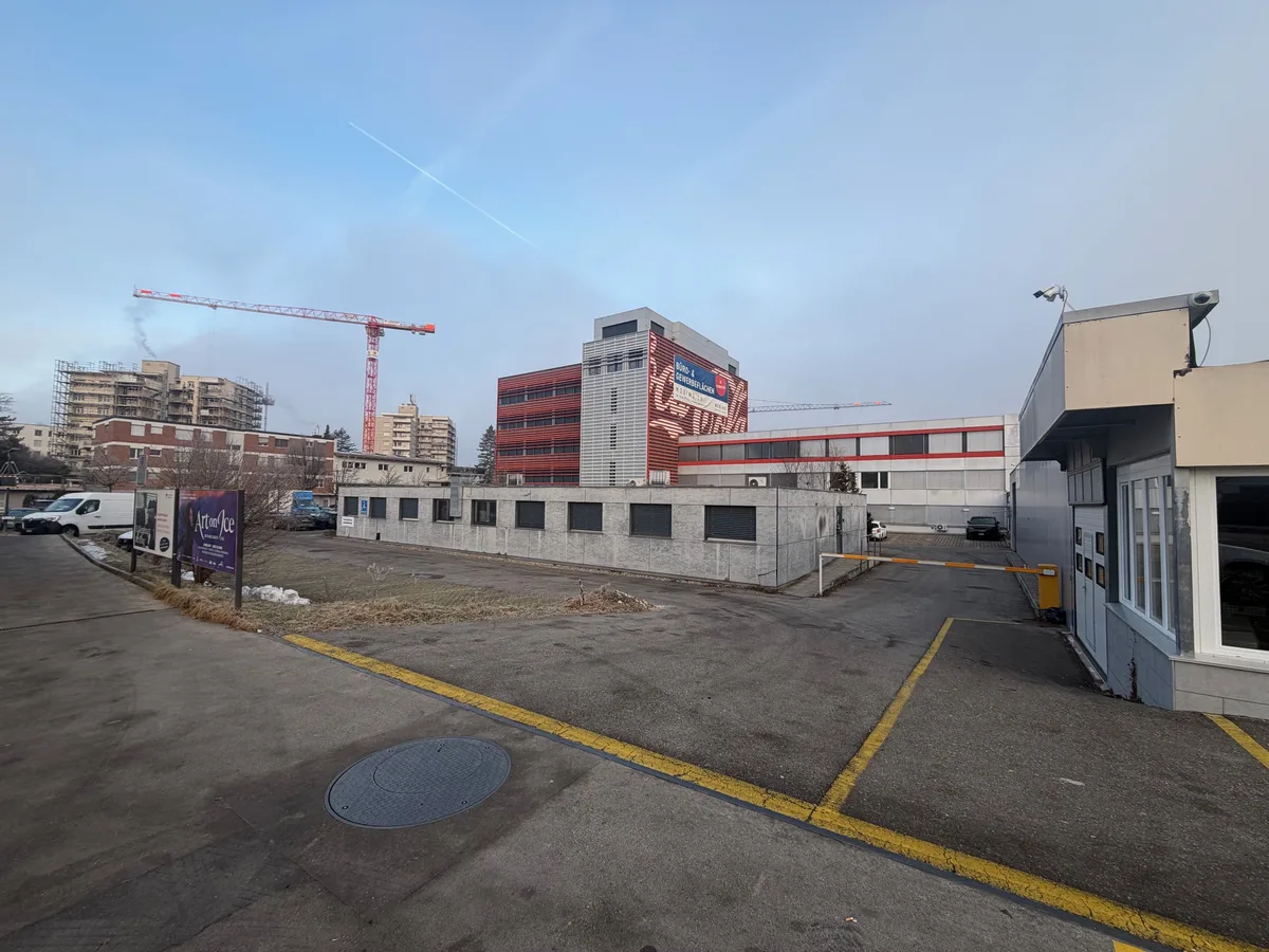 Sicht auf das ehemalige Erni-Areal zwischen dem Dorfzentrum von Brüttisellen und dem Bahnhof Dietlikon. Sicht auf Strasse und Parkplätze in einer Gemeinde.