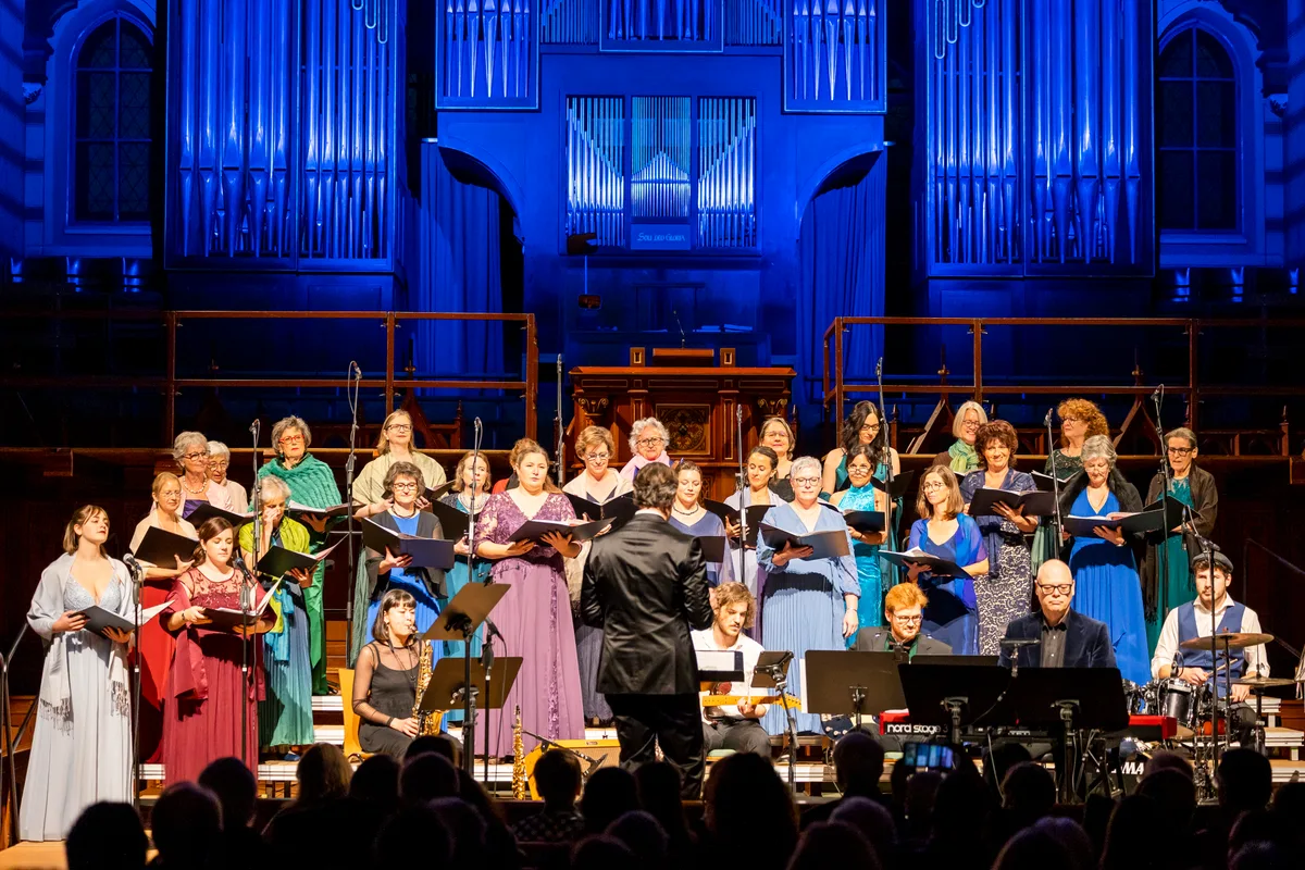 Sie waren bereits in der Tonhalle zu sehen: Der Bubiker Frauenchor singt auch in Wetzikon für Hans Georg Nägeli. Ein Frauenchor auf einer Bühne. Ein Mann dirigiert.