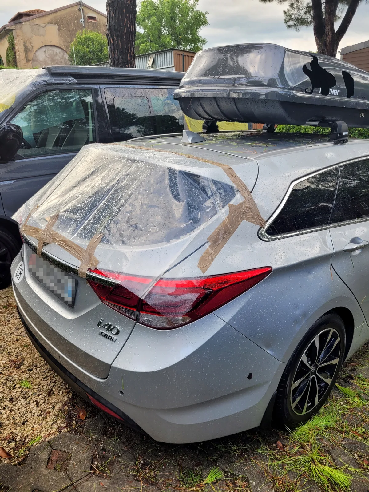 Die zertrümmerte Heckscheibe eines Autos mit einem Plastiküberzug.