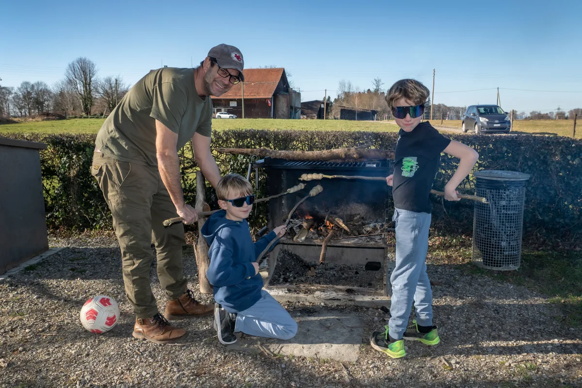 Michael, sein neunjähriger Sohn Henry und dessen Schulkollege aus Lindau beim Backen von Schlangenbrot. Sie kommen jedes Jahr zu dieser Grillstelle. So früh im Jahr waren sie aber noch nie hier. Der Frühling ist da.