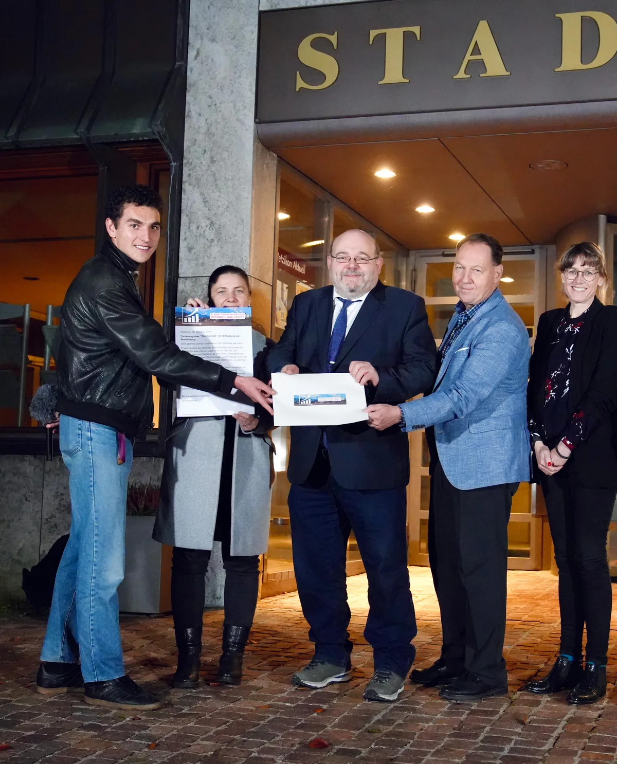 Fünf Menschen stehen vor dem Stadthaus Wetzikon.