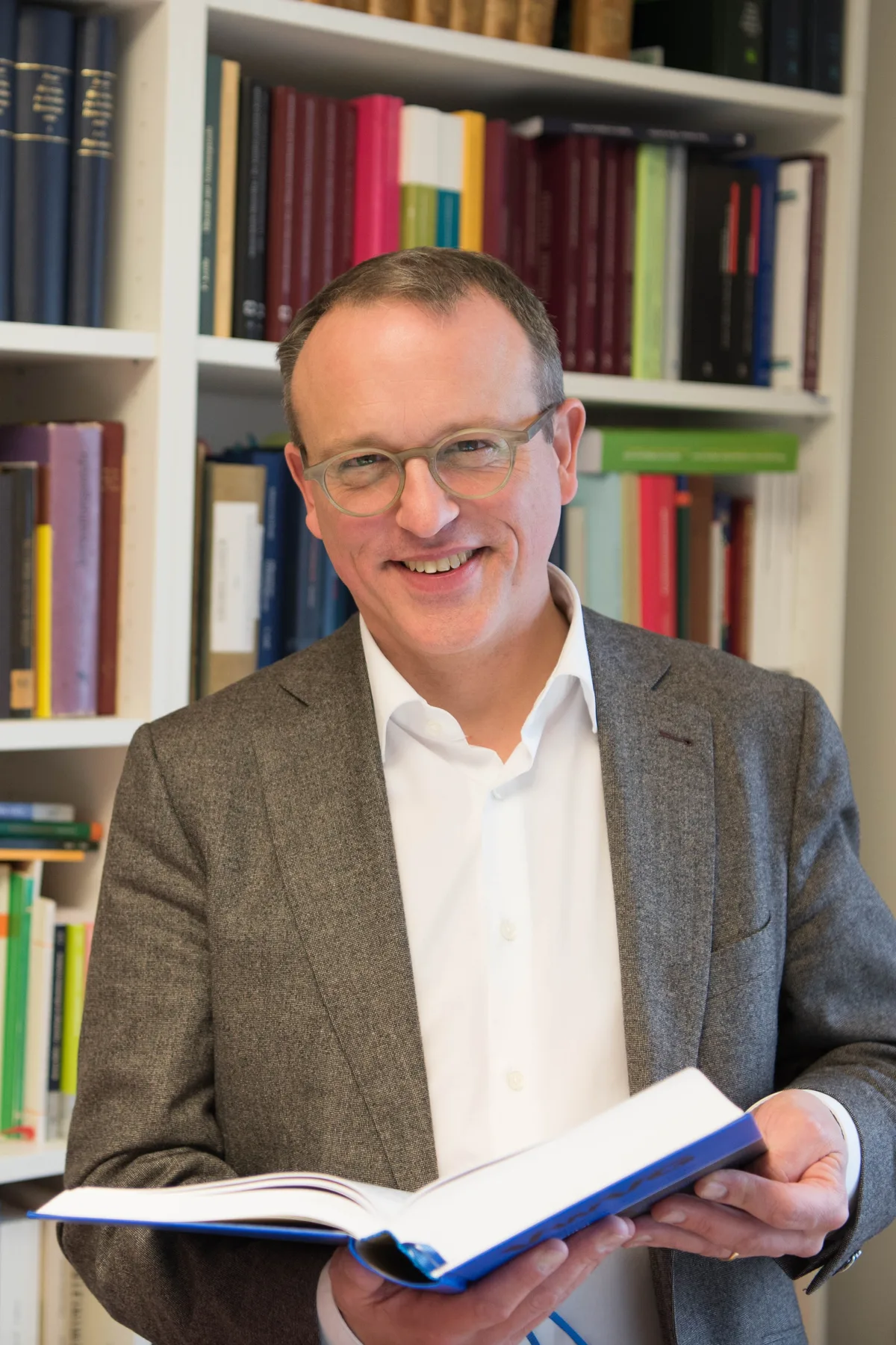 Benjamin Schindler mit einem Buch in der Hand.
