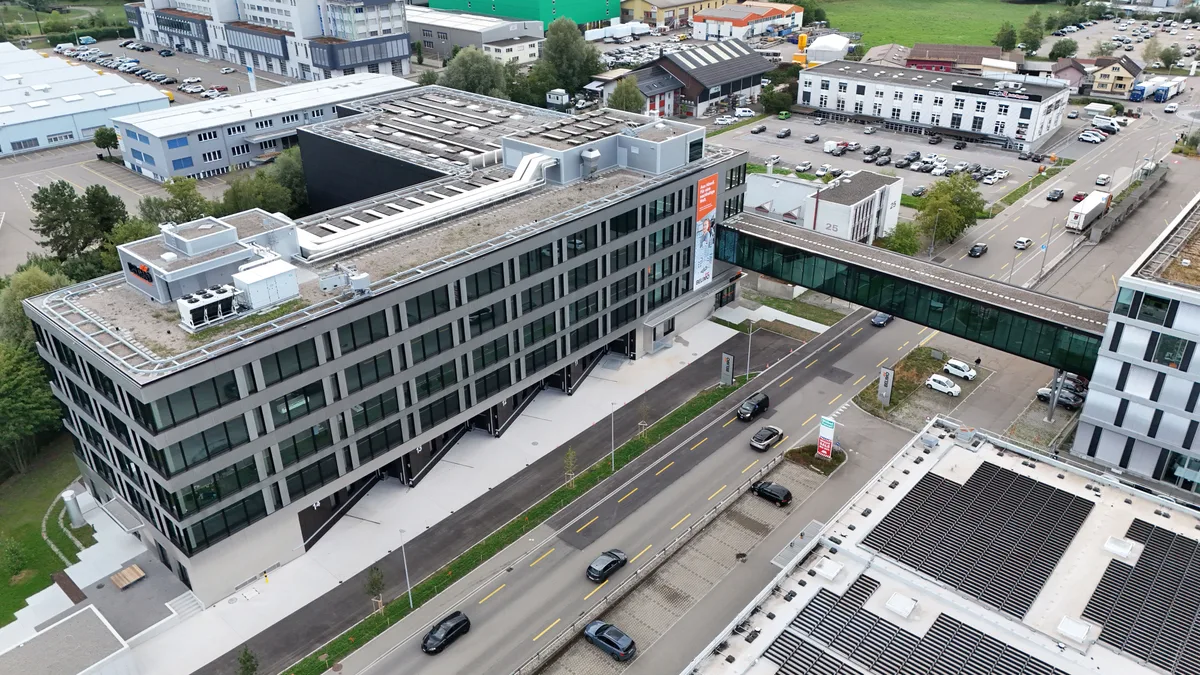 Verbindung von alt und neu: Die Passerelle über die Wässeristrasse leuchtet in der Nacht im Belimo-Orange.