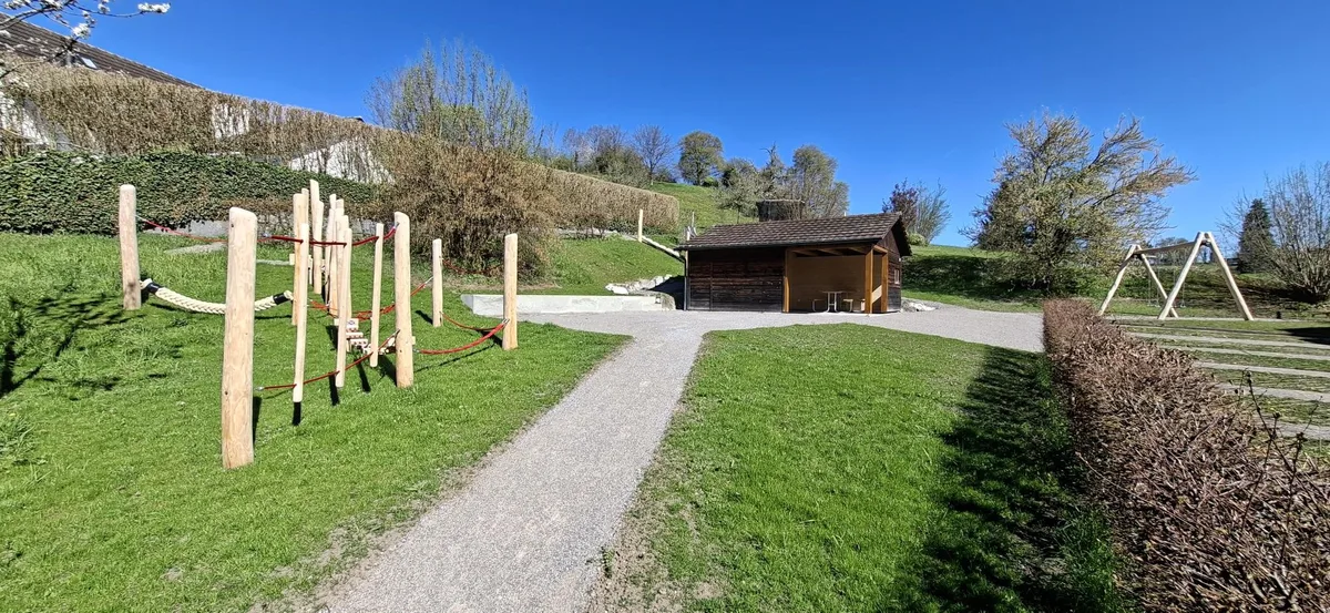 Der Spielplatz ist mit einer Rutschbahn, Schaukel und Balancier-Parcours ausagestattet. Der einstige Schopf dient als überdachter Sitzplatz. Der Spielplatz ist mit einer Rutschbahn, Schaukel und Balancier-Parcours ausagestattet. Der einstige Schopf dient als überdachter Sitzplatz.