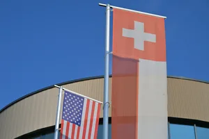 Man sieht eine Schweizer und eine US-amerikanische Flagge Man sieht eine Schweizer und eine US-amerikanische Flagge