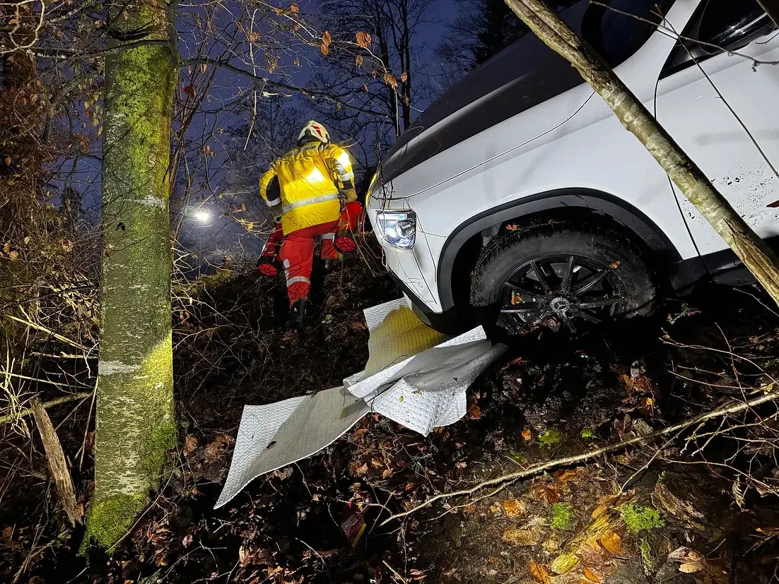 Feuerwehrleute sichern das Fahrzeug, das aufgrund von Glatteis von der Strasse abgekommen ist. Feuerwehrleute sichern das Fahrzeug, das aufgrund von Glatteis von der Strasse abgekommen ist.