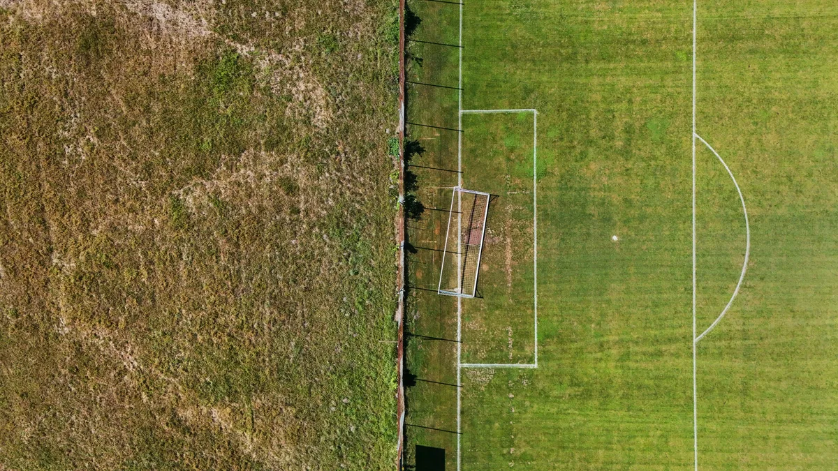 Ein Bild der Kontraste: links eine karge Wiese, rechts der bewässerte Fussballplatz in Greifensee. 