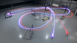 Intelligente selbstnavigierende Hochgeschwindigkeitsdrohne (blau) fliegt den Rundkurs schneller als die vom Weltmeister gesteuerte First-Person-View-Drohne (rot). Intelligente selbstnavigierende Hochgeschwindigkeitsdrohne (blau) fliegt den Rundkurs schneller als die vom Weltmeister gesteuerte First-Person-View-Drohne (rot).