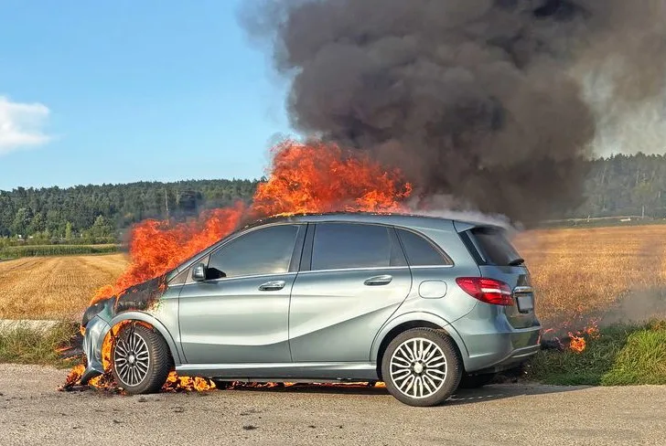 26888777-1 Flammen schiessen aus dem Motorraum des Mercedes.