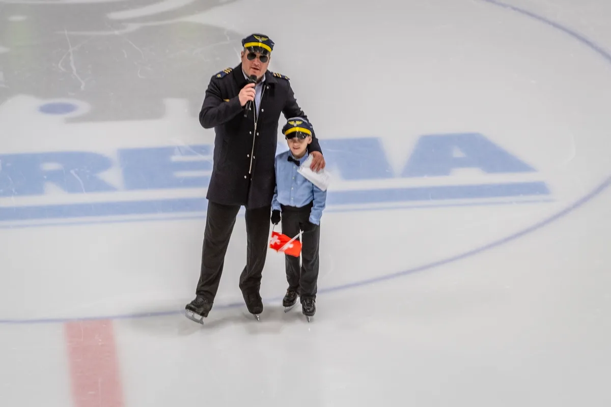 Ein erwachsener Mann und ein kleiner Junge auf dem Eis: beide mit Pilotenmütze.