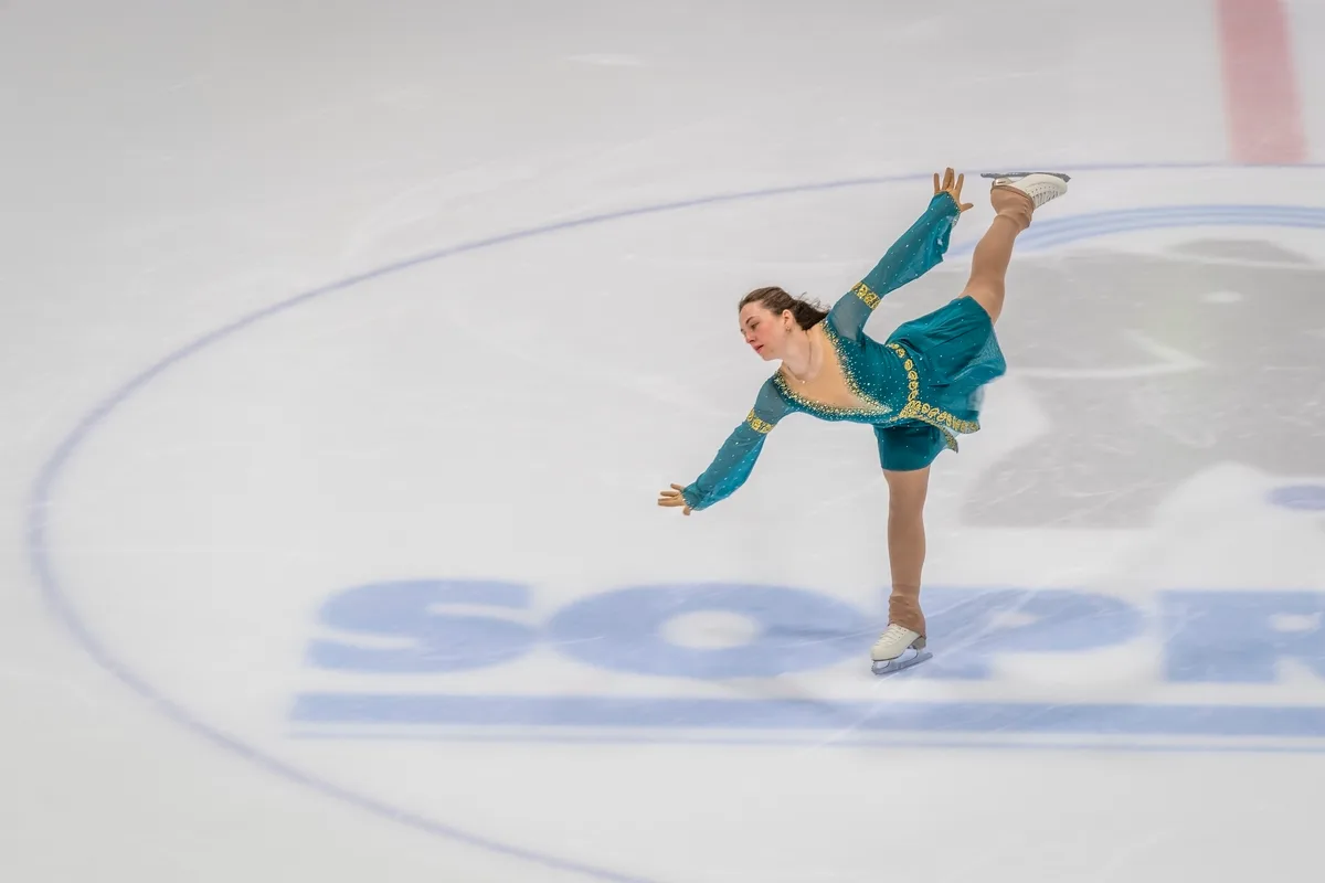 Jael auf dem Eis mit blauem Kostüm.