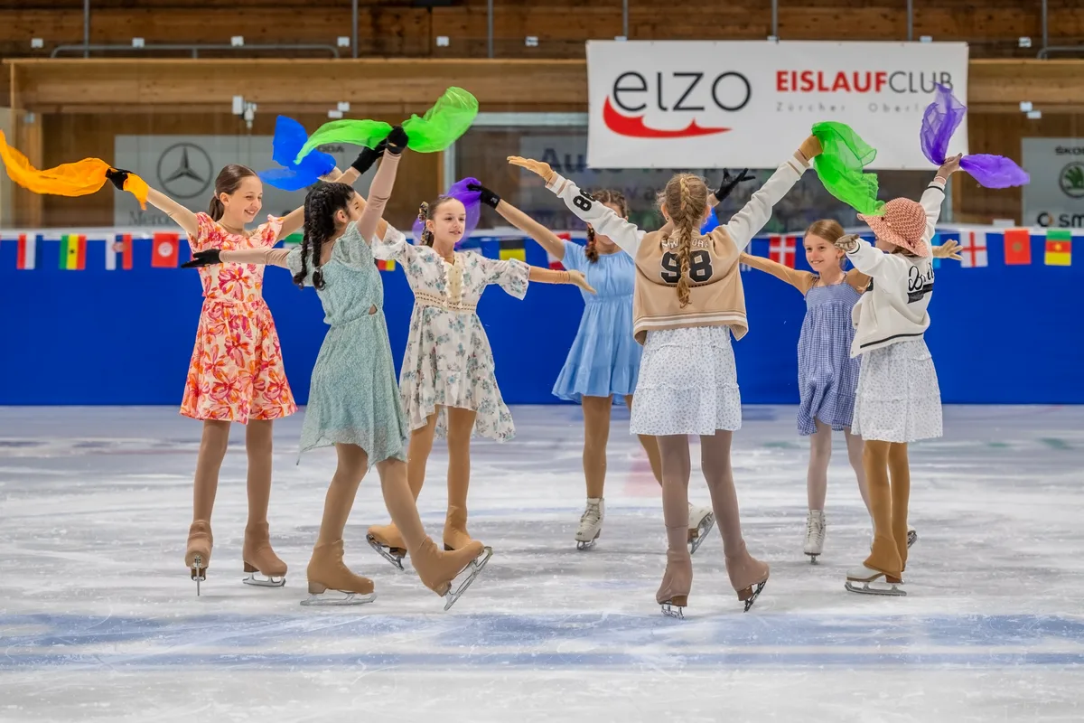 Mädchen mit Tüchern auf dem Eis im Kreis.