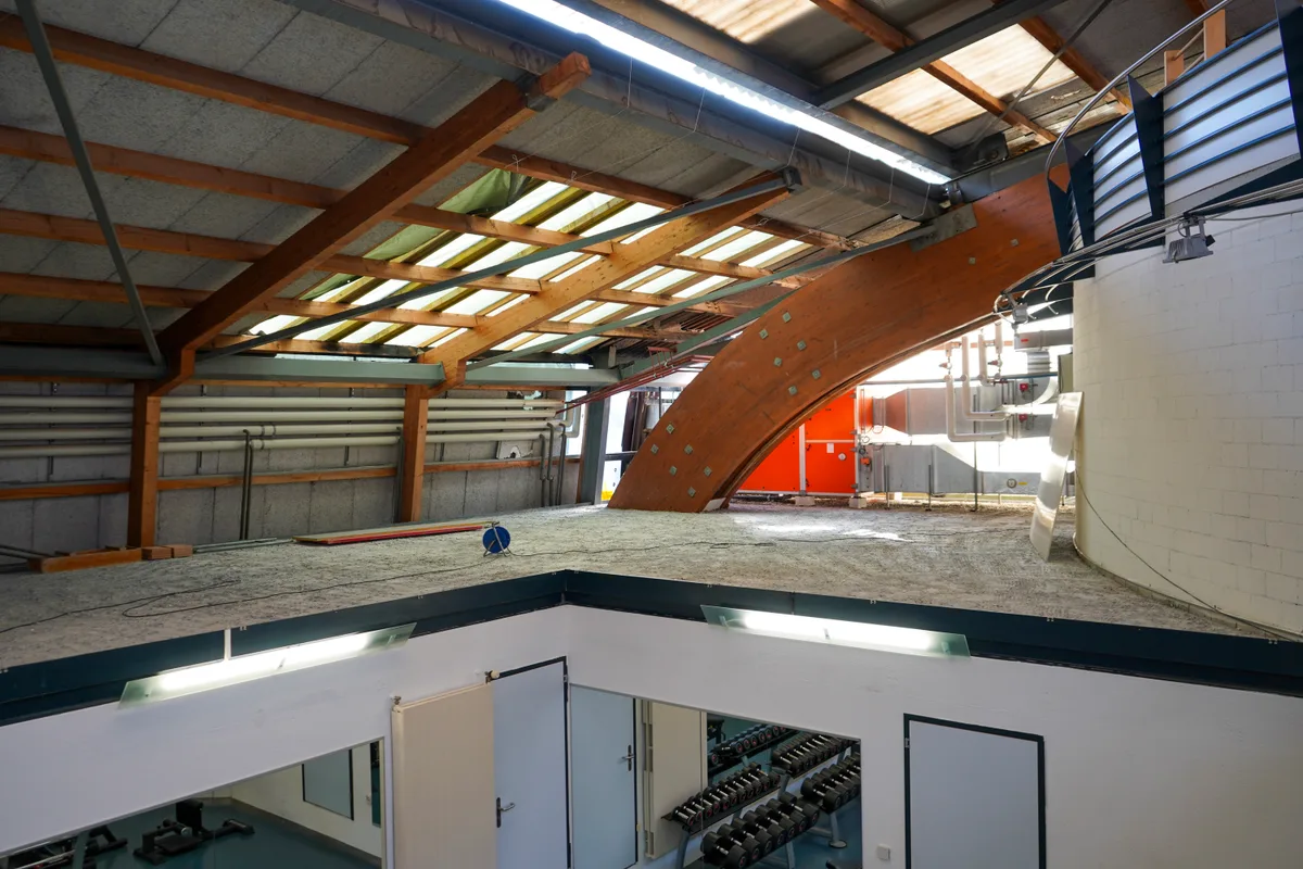 Man sieht eine Ecke im Dach des Sportcenters mit Lüftungsschächten und Leitungen.