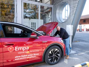 30620844-10 Ein umgerüstetes E-Auto lädt kabellos über die im Boden integrierte Spule – der Ladevorgang startet automatisch, sobald das Fahrzeug korrekt parkiert ist. Bild: Empa