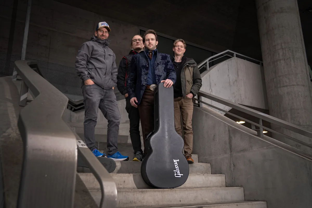 Florian Fox und die Band stehen auf einer Treppe.