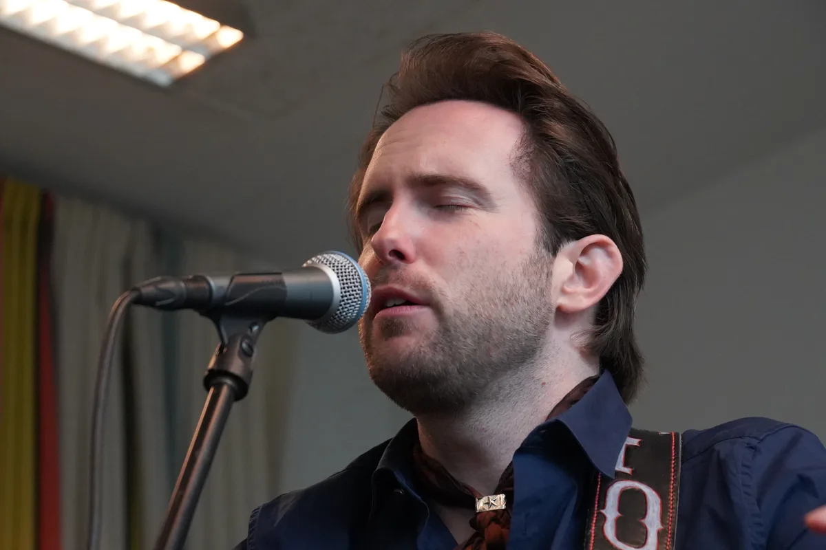 Florian Fox singt in ein Mikrofon.