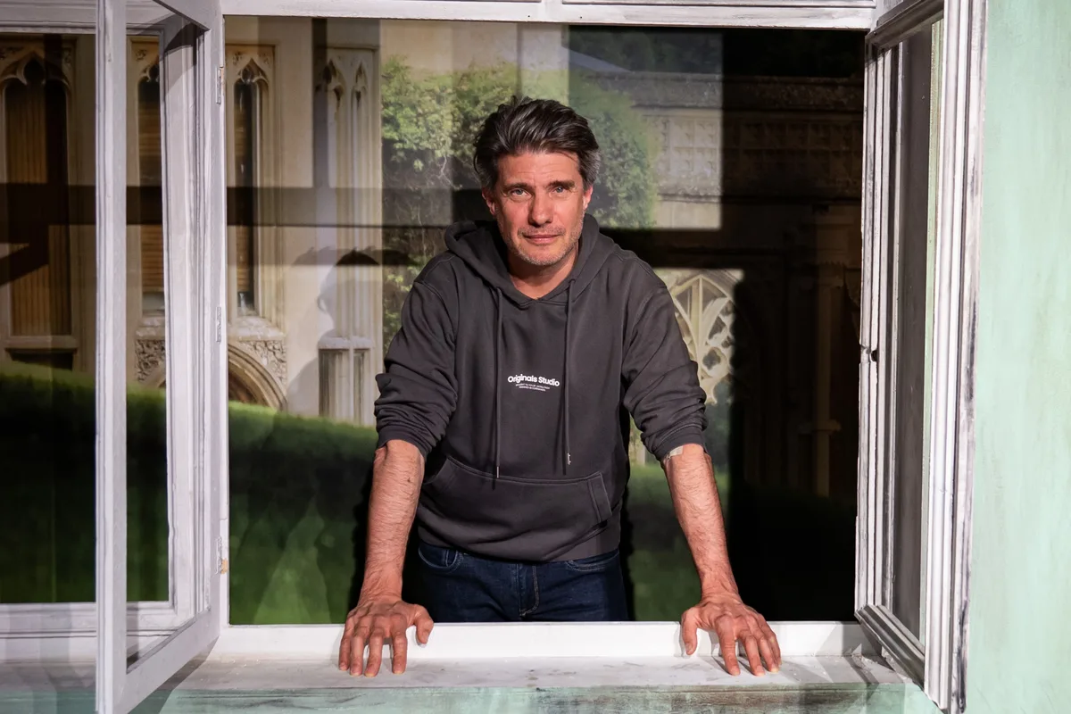 Jan von Rennenkampff stützt sich auf einen Fensterrahmen auf der Bühne.