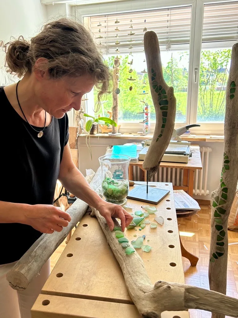 Man sieht Corinne Frauchiger beim Auslegen eines Mosaiks.