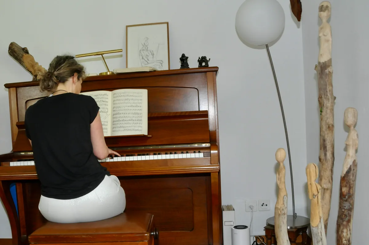Corinne Frauchiger spielt Klavier inmitten ihrer Kunstwerke.