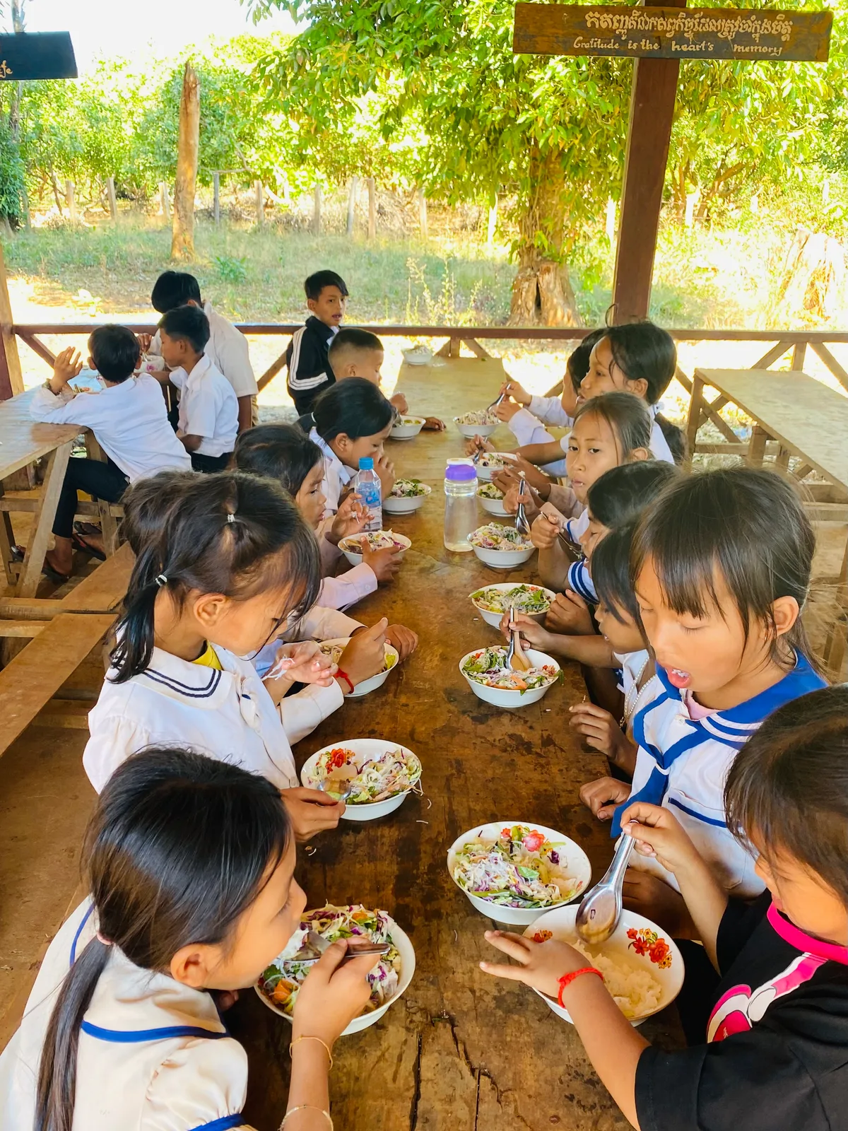 Man sieht Kinder in Kambodscha beim Mittagessen.