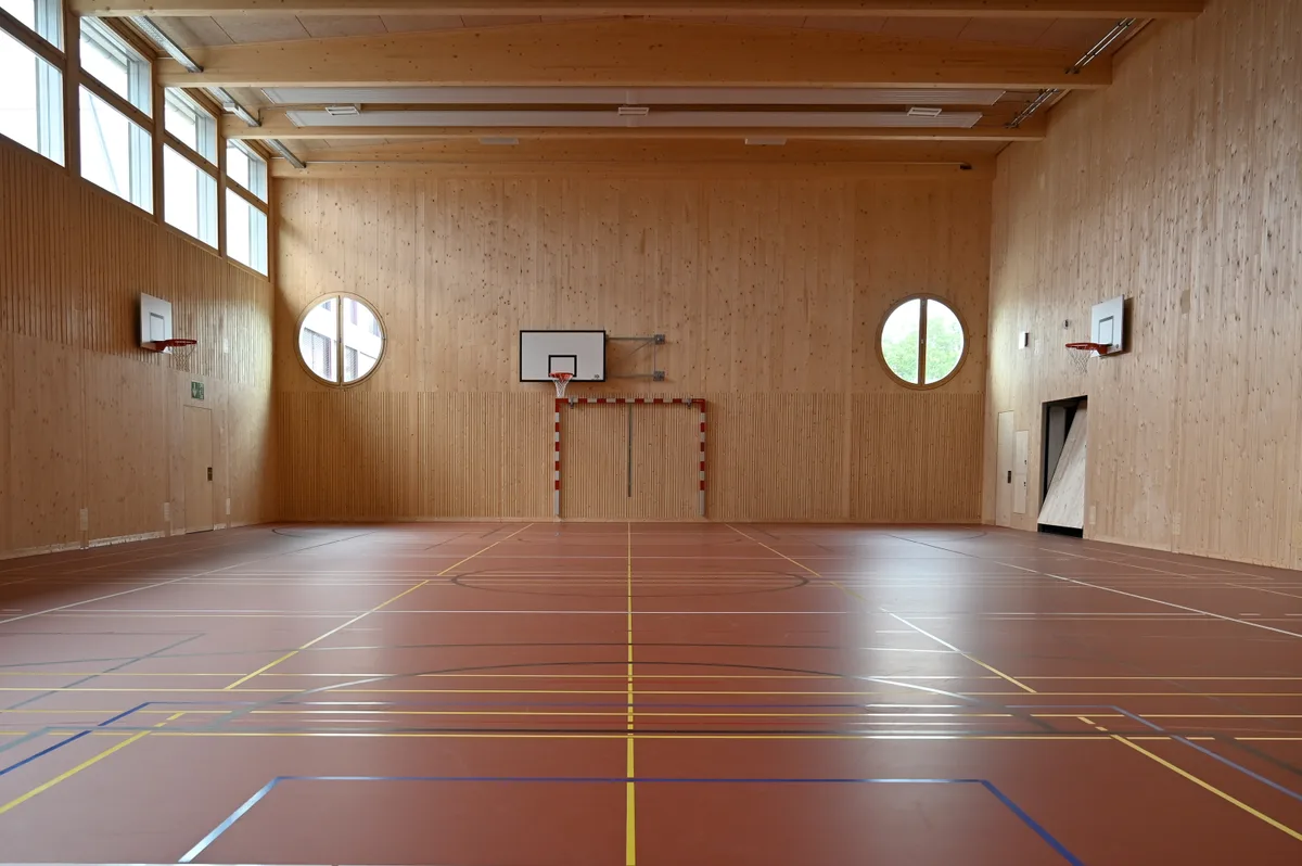 Holz ist ein sichtbar dominierendes Element in der Sporthalle. Einweihung der Kantonsschule Stadelhofen, Filiale Dübendorf