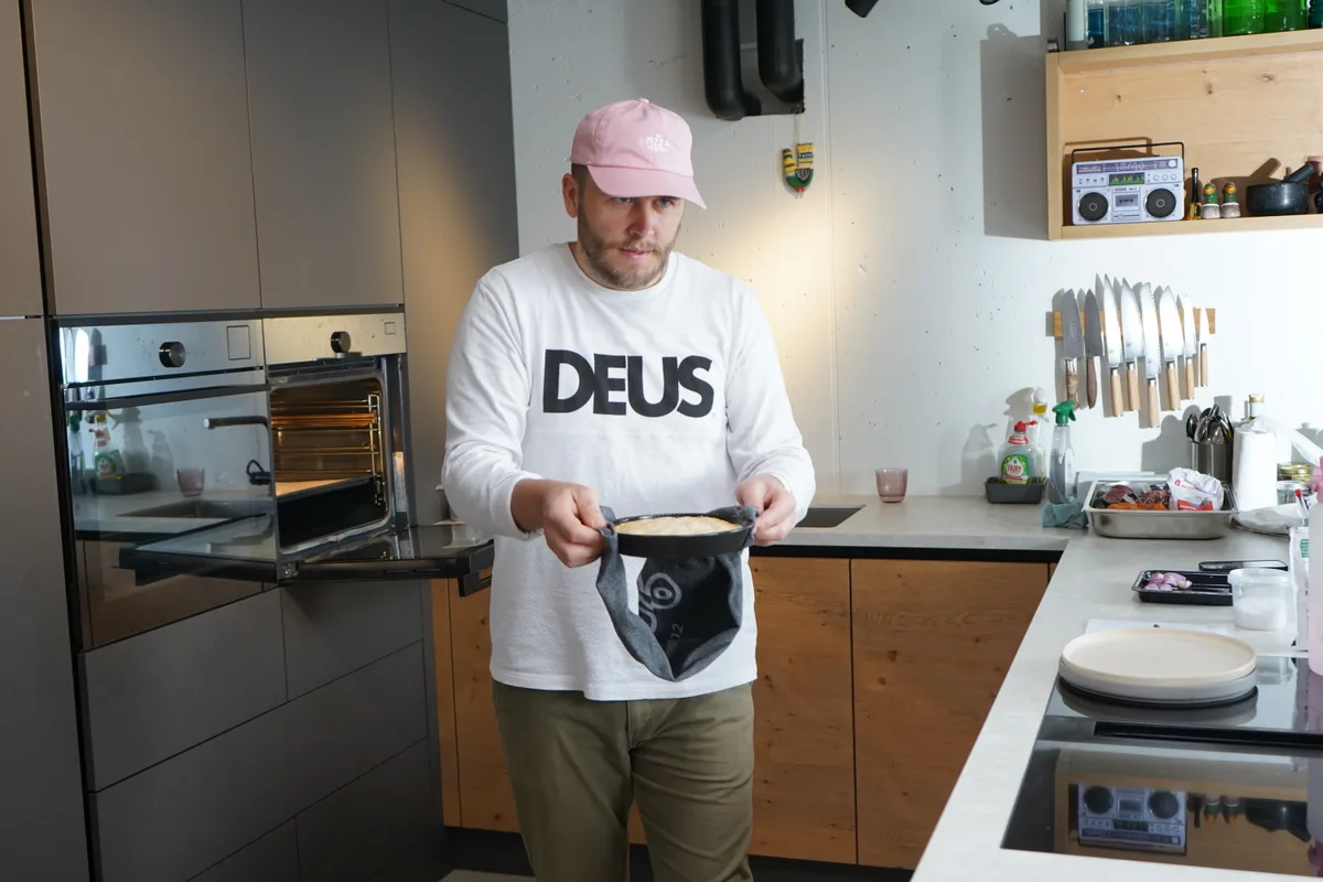 Sandro Zinggeler holt die Zwiebeltarte aus dem Ofen.
