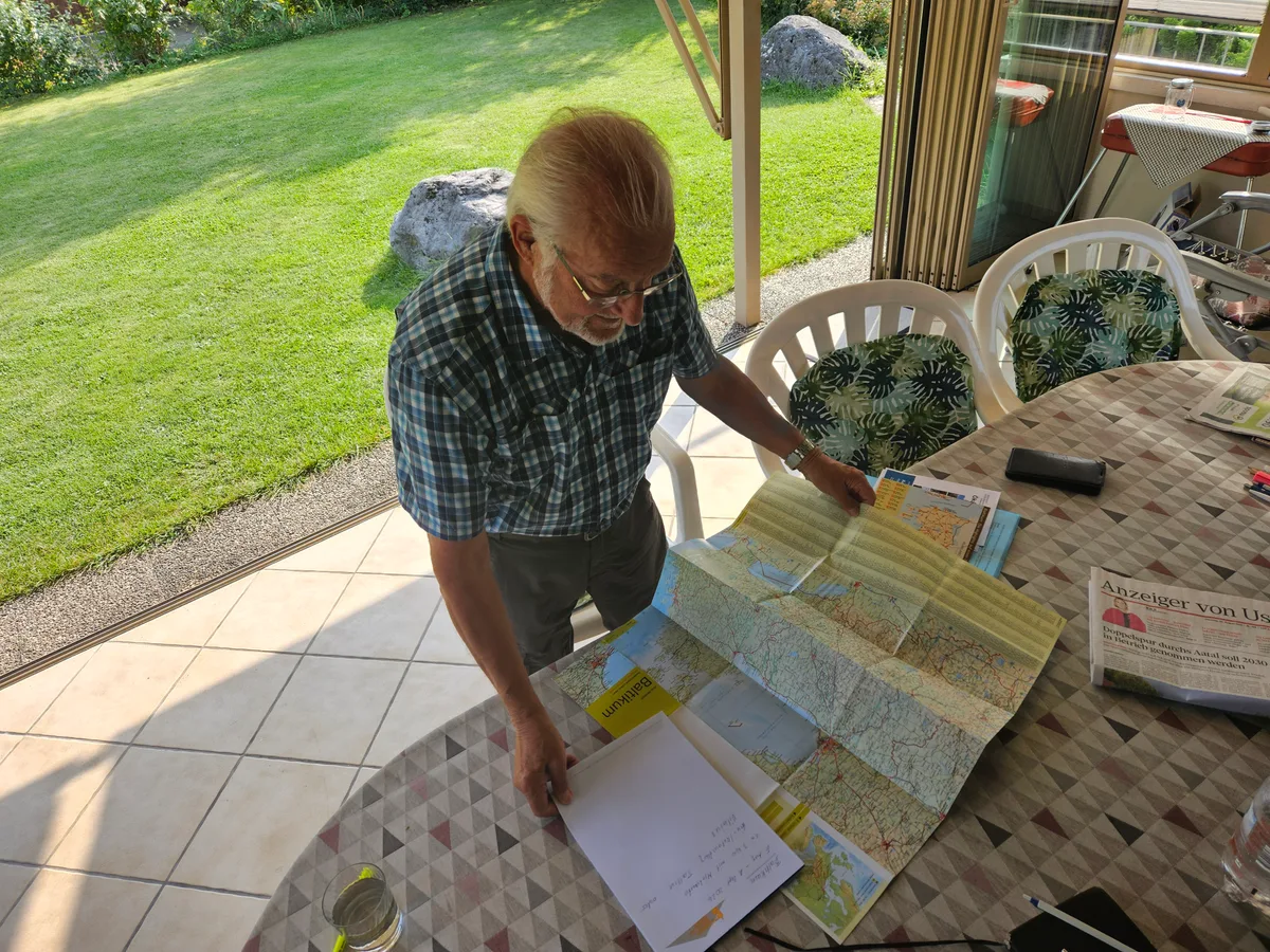 Lange stillsitzen kann Hans Deflorin nicht: Er plant schon wieder die nächste Reise. Hans Deflorin breitet eine Karte aus.