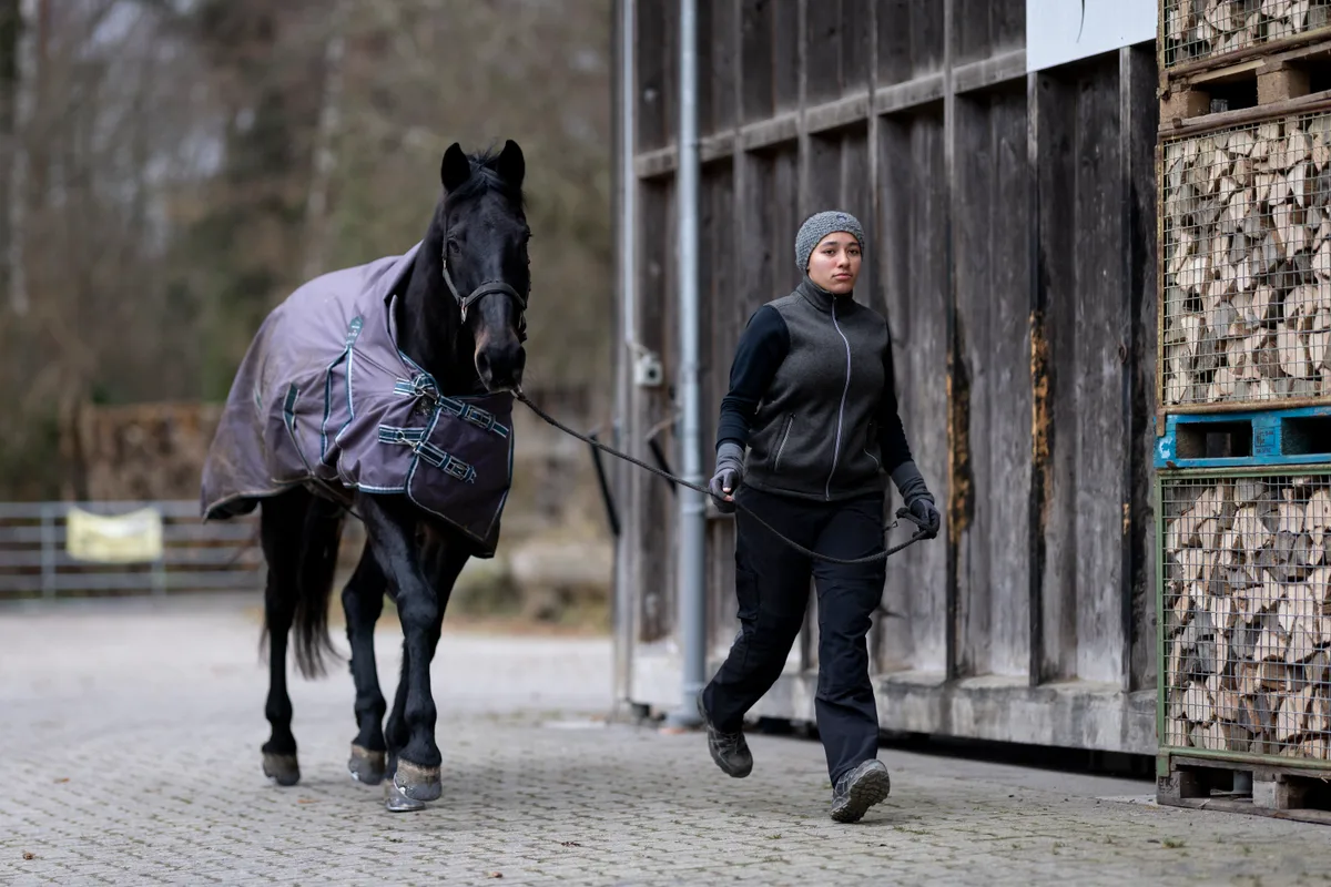 Rona Jimmy läuft mit dem Pferd im Trab.
