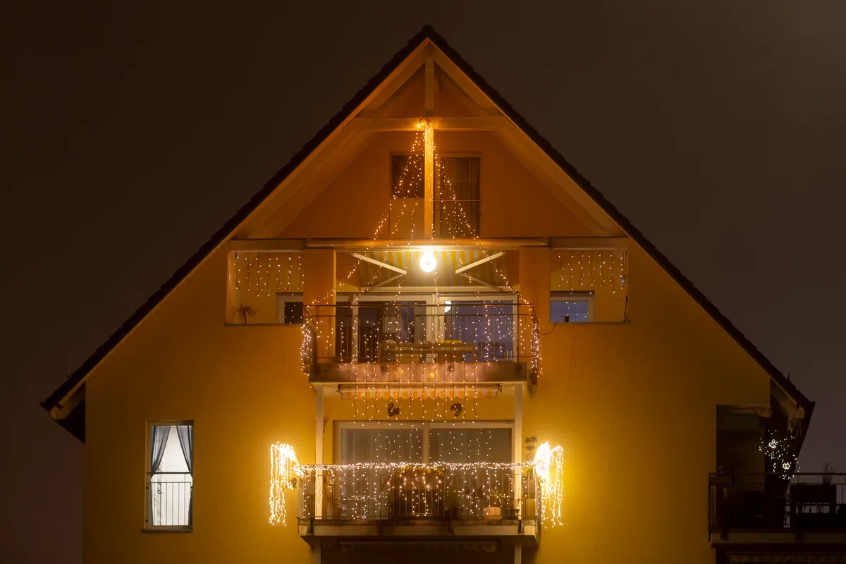 Beleuchtete Hausfassade in Volketswil. Nächtliche Weihnachtsbeleuchtung.