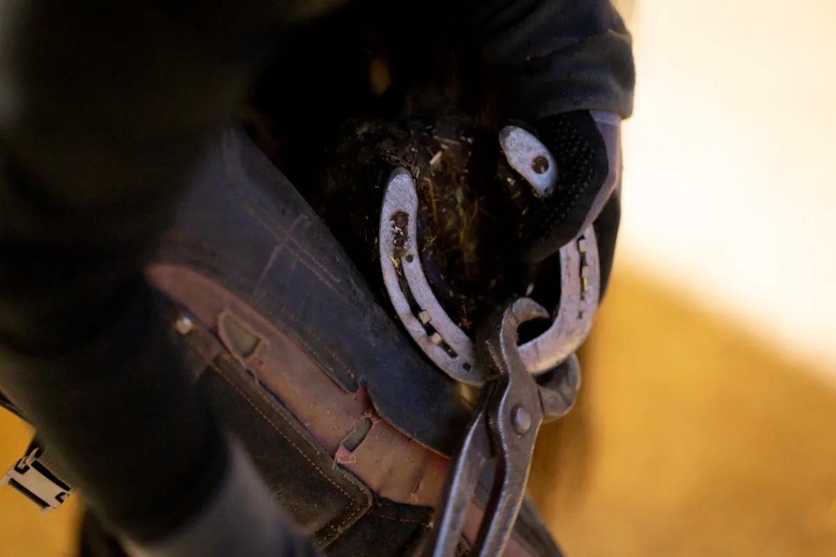 Rona Jimmy entfernt mit einer Zange das Eisen.