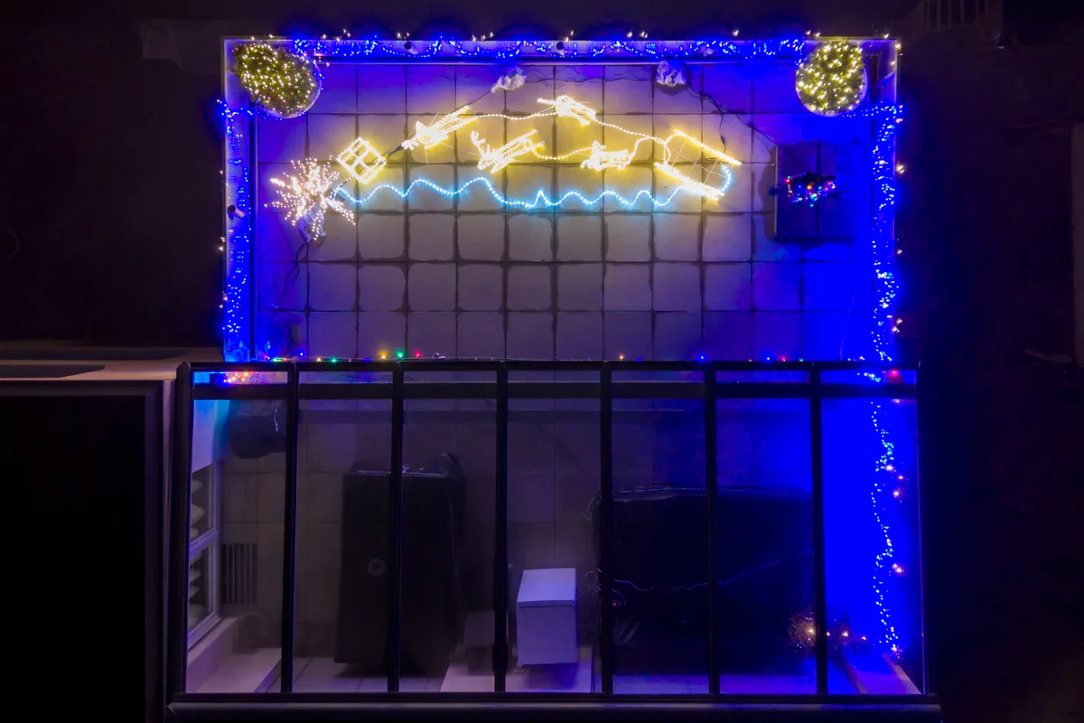 Luftaufnahme eines Sitzplatzes mit Weihnachtsbeleuchtung in Volketswil. Nächtliche Weihnachtsbeleuchtung.