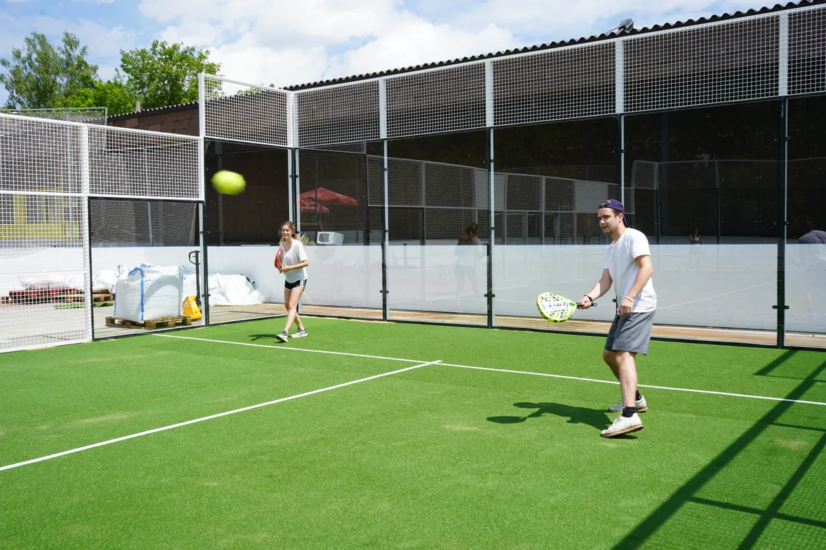 Zwei Personen spielen eine Art Tennis.