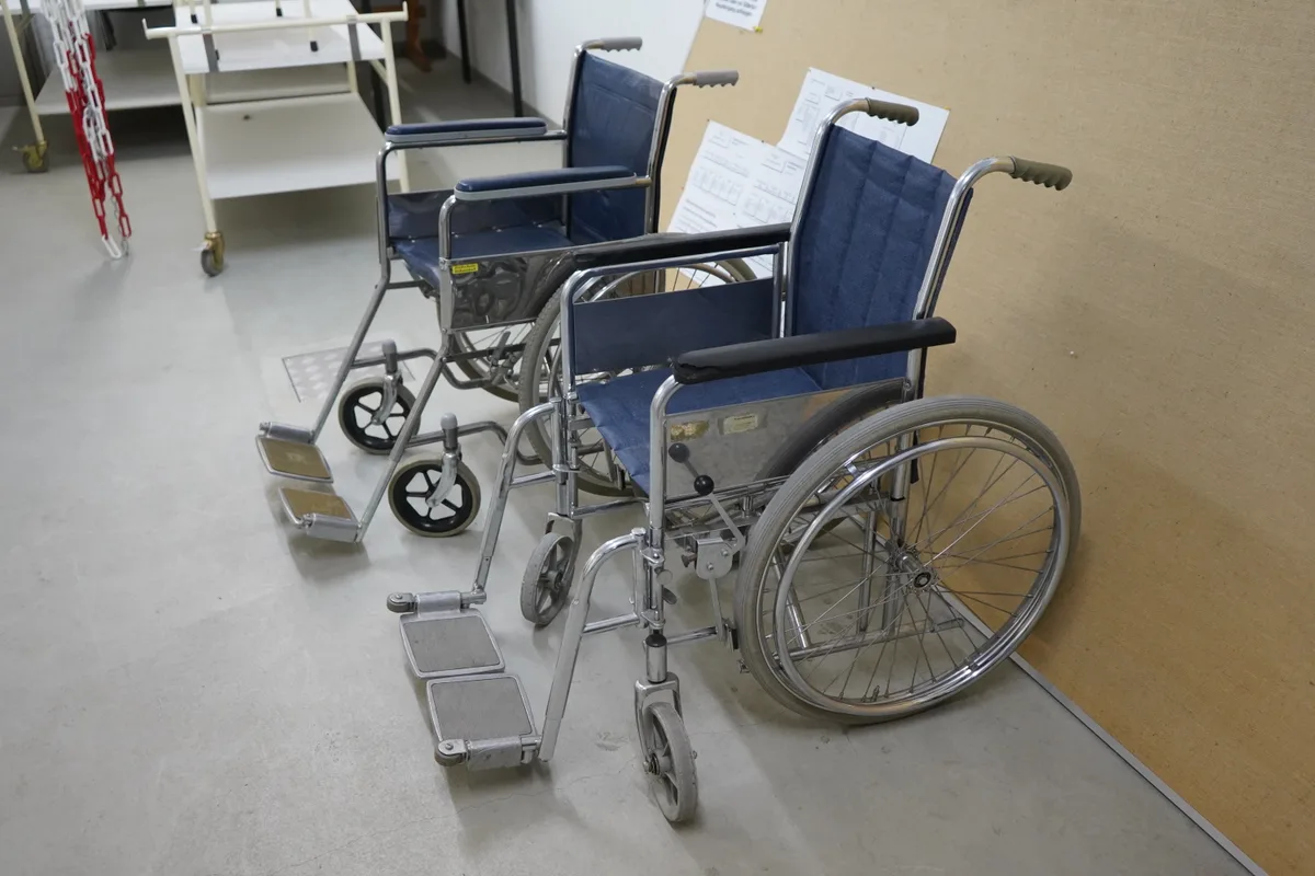 Zwei alte Rollstühle.