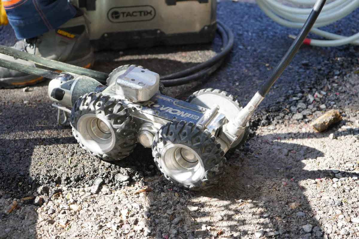 Ein Kanalisationsroboter steht auf dem Boden.