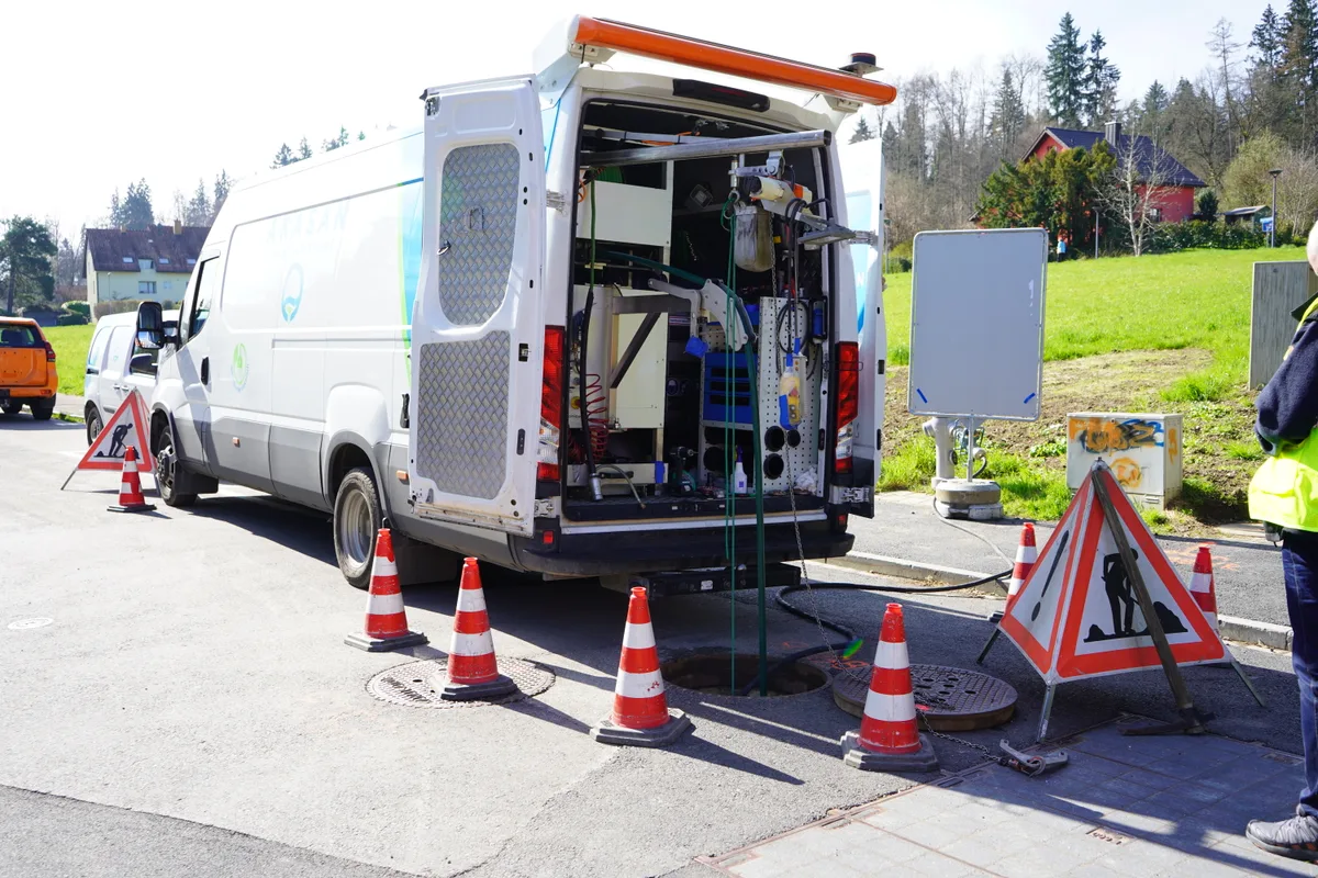 Ein Arbeitsbus steht vor einem offenen Schacht.
