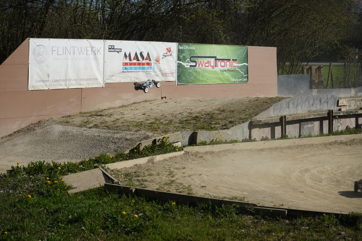 Ein Modellauto fliegt über eine Schanze.
