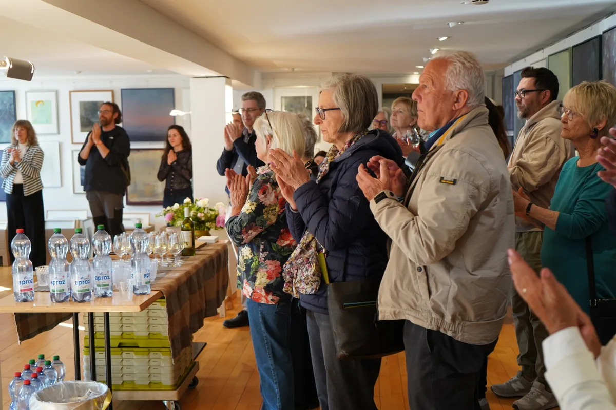 Leute applaudieren an der Vernissage.
