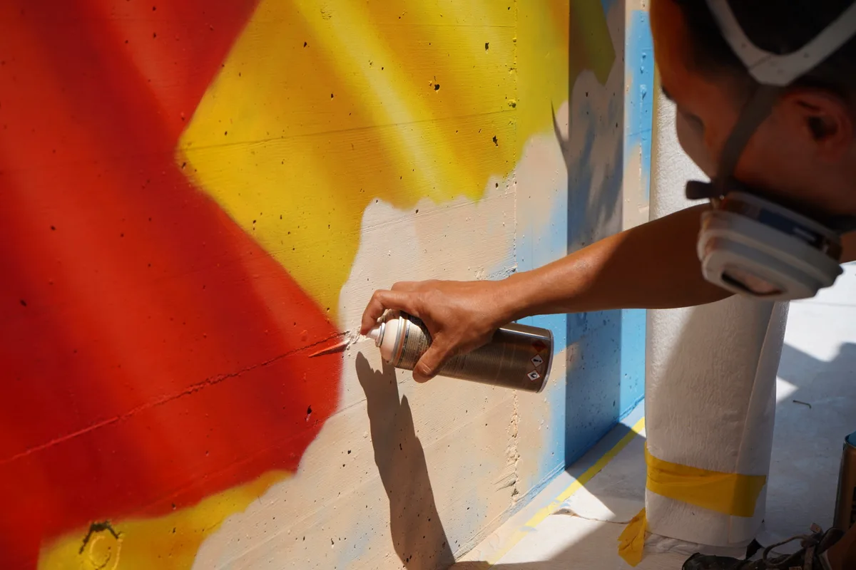 Alex Hohl sprayt eine Wand an.