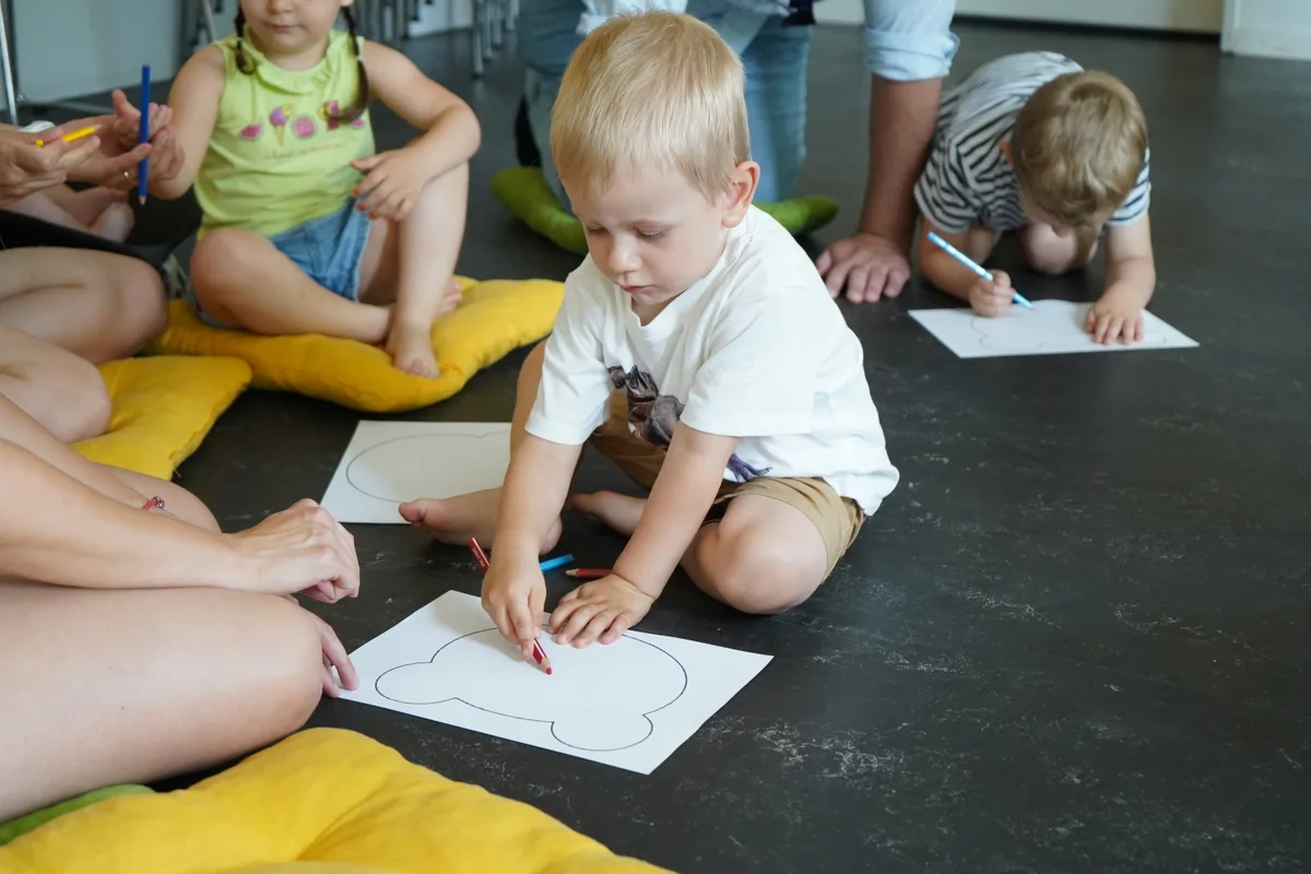 Ein Kind zeichnet auf ein Blatt.