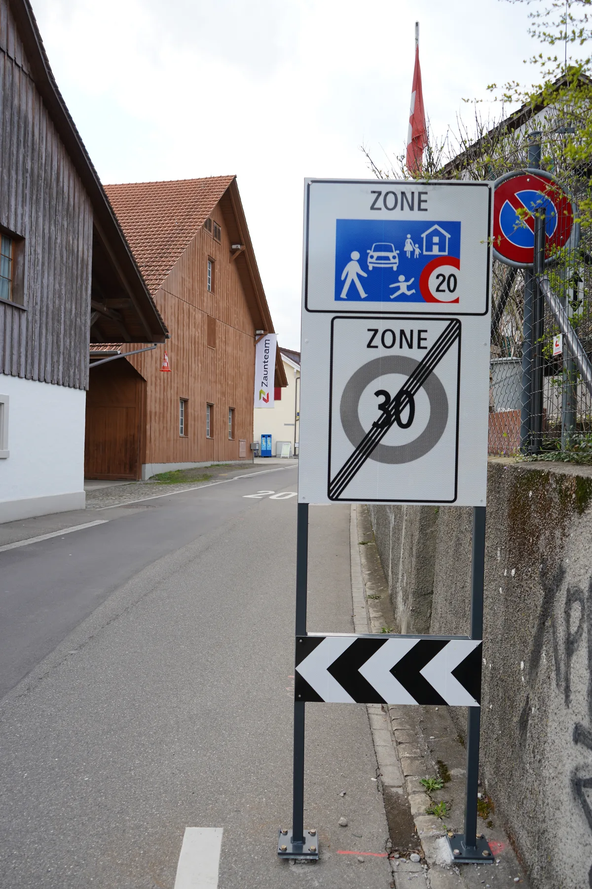 Ein Dorfzentrum mit Häuser und Tempo 20 Tafeln. Es sind Strassen im Volketswiler Dorfteil Gutenswil.