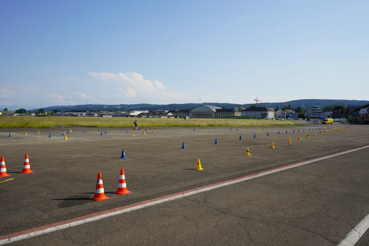 Viele farbige Pylonen auf einem Flugplatz.