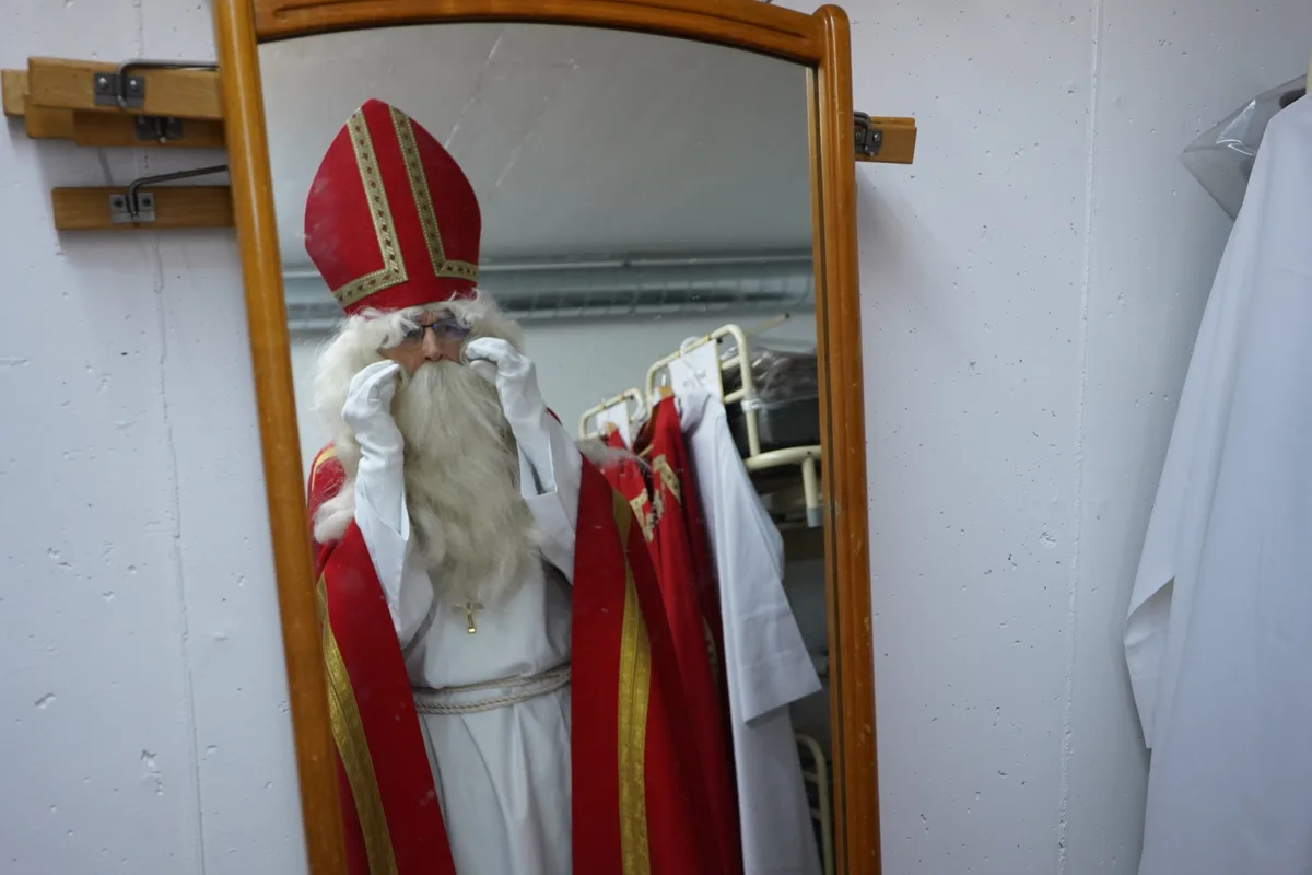 Ein Samichlaus schaut in einen Spiegel.