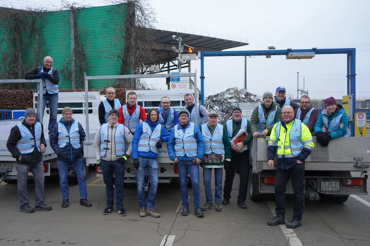 17 Personen vor drei Lastwagen.