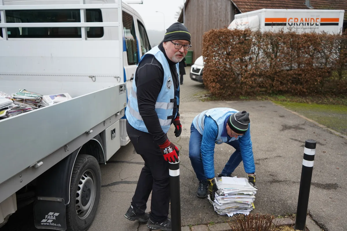 Zwei Männer sammeln Papier.