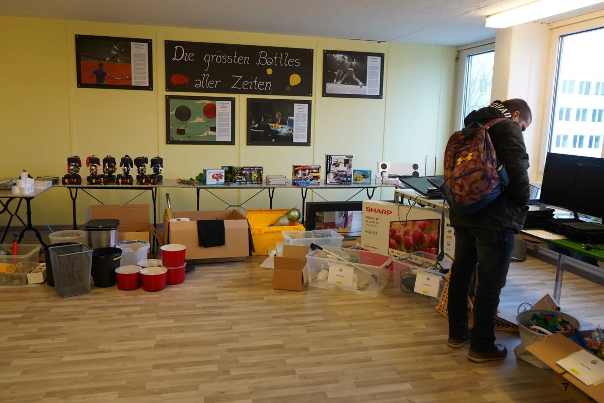 Eine Person schaut sich die Waren auf dem Tisch an.