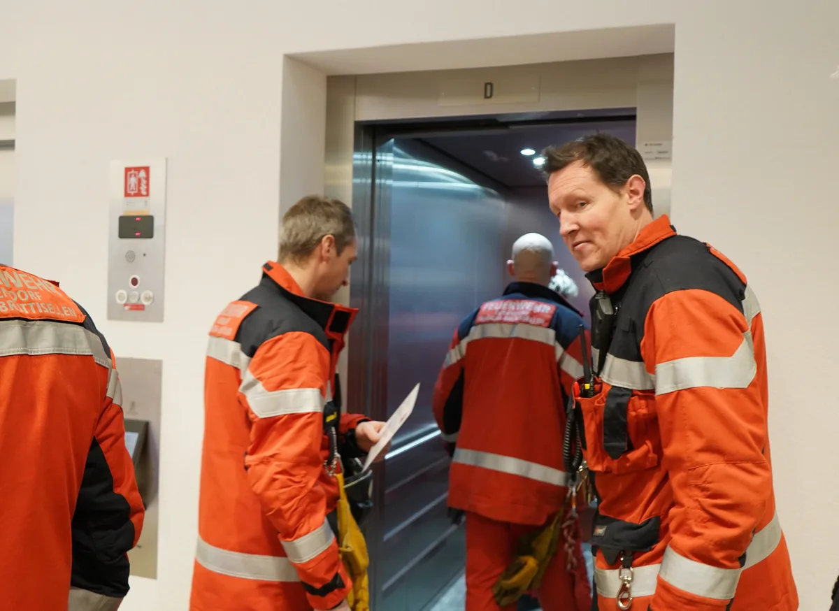 10ptMehrere Feuerwehrleute in einem Lift.