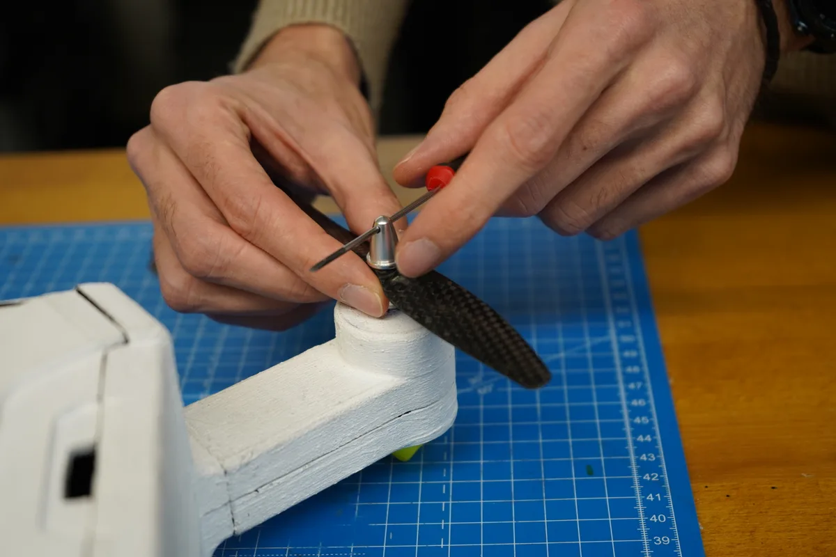 Eine Hand dreht an einem Propeller.