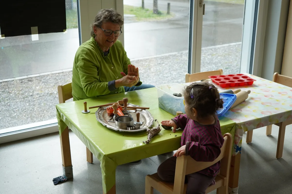 Eine Frau und ein kleines Mädchen an einem Tisch.