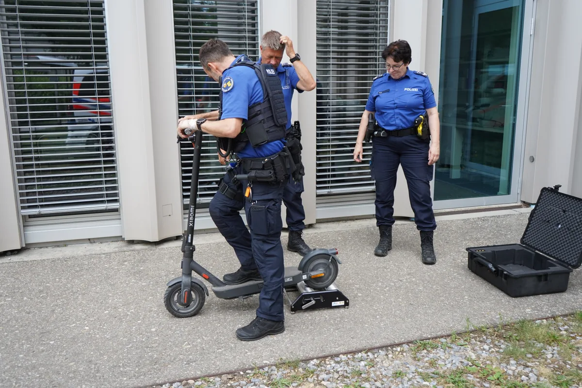 Drei Polizisten prüfen den Roller.